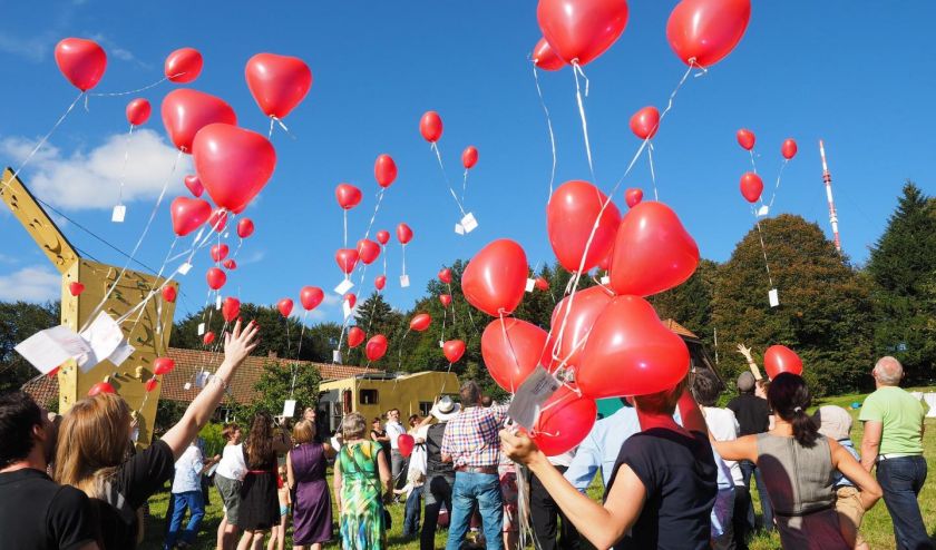 Eine Gruppe von Personen lassen Luftballone in den Himmel